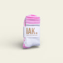 IAK Blossom pink and white organic cotton grip socks with full-coverage PVC grip, folded on a beige background