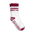 A pair of white crew socks with dark red accents, featuring the letters 'IAK.' on the side, a grip pattern on the sole, and a dark red toe and heel.